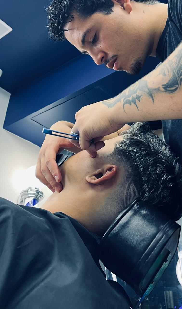 Barbeiro fazendo acabamento na barba